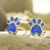 Paw necklace pendant on sandy rock closeup